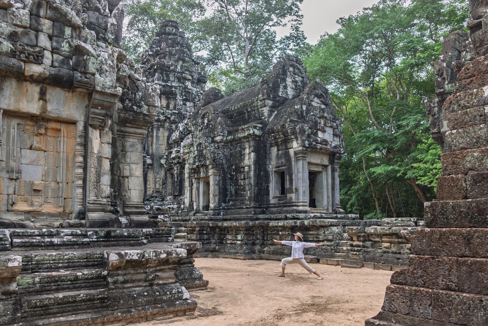 A practitioner in Warrior pose among the Angkor temples