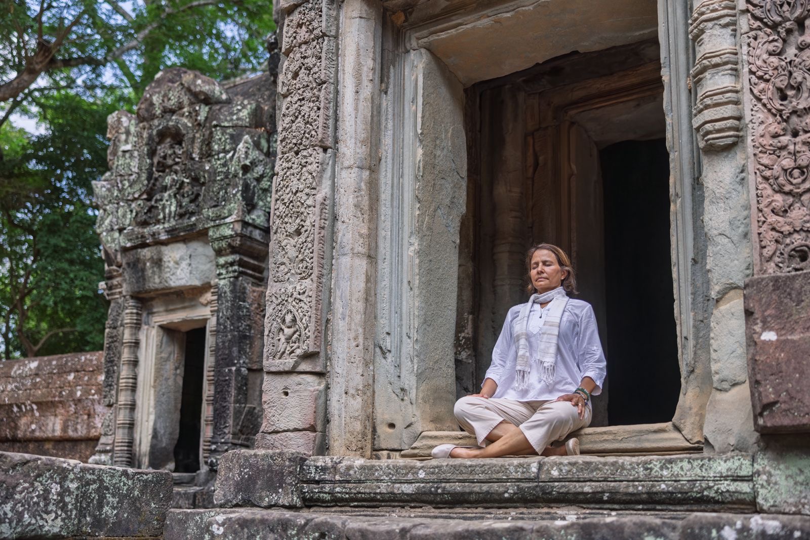 Delphine, Iyengar Yoga teacher, in meditation at an Angkor temple