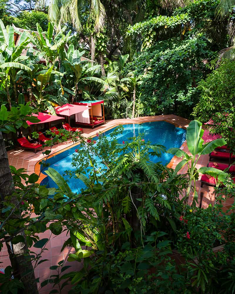 Tropical pool surrounded by lush gardens at Angkor Village Hotel