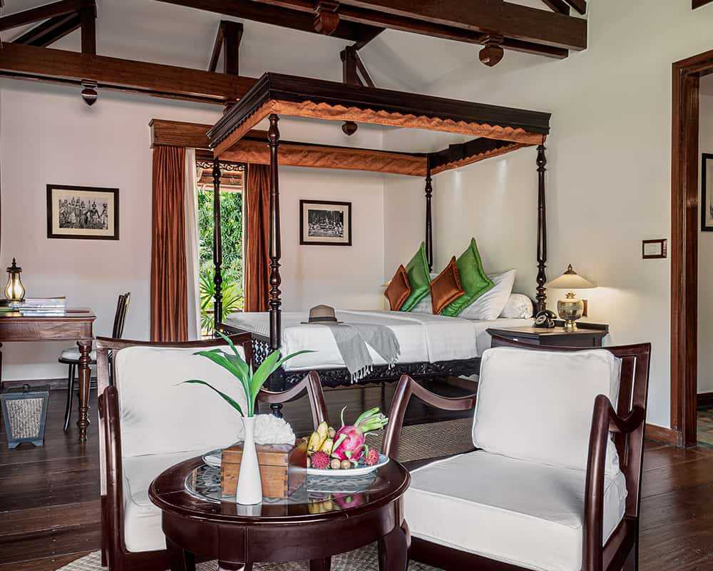 Khmer suite with four-poster bed and teak sitting area